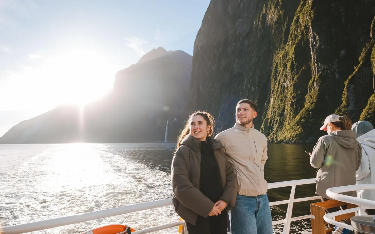 Passengers on the deck of a cruise boat in Milford Sound against the light