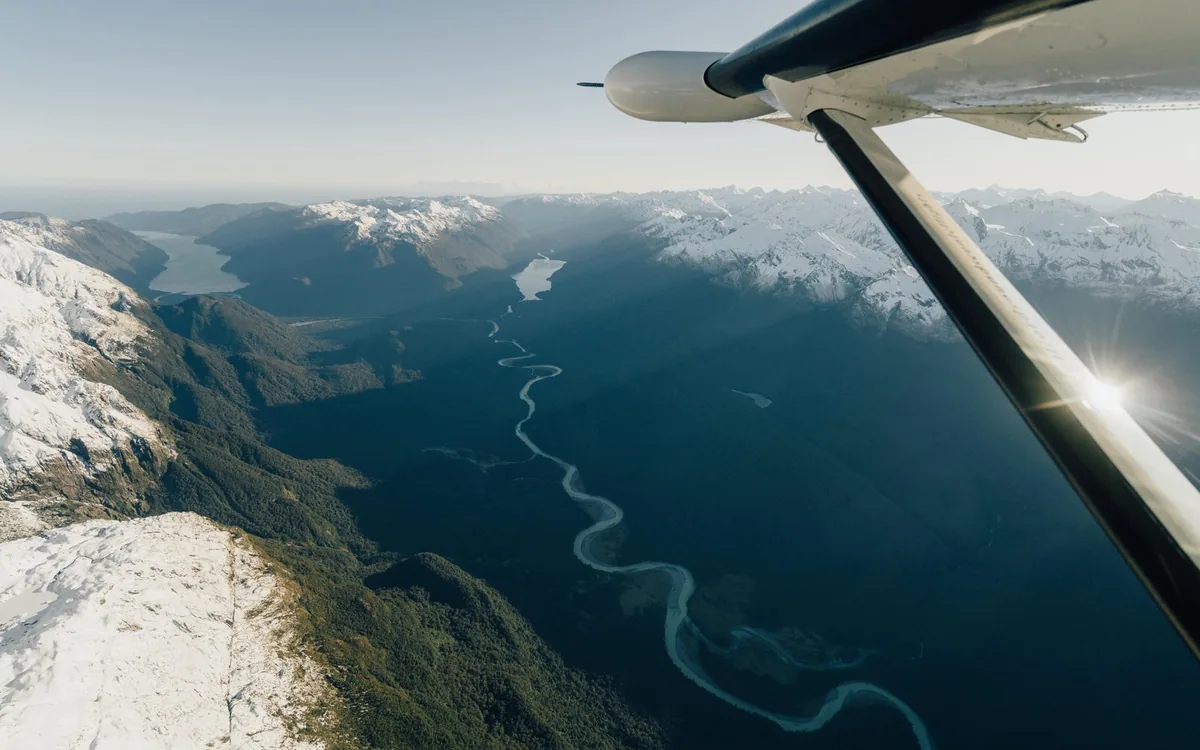 The wing of a light aircraft over the Southern Alps on the way to Milford Sound